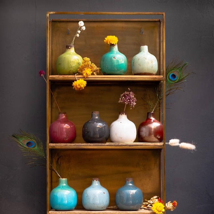 Étagère en bois sur laquelle sont posés des vases colorés.