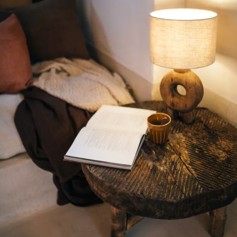 lampe pied bois rond abat jour couleur lin sur une table 