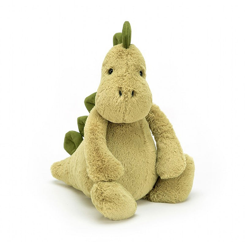 Peluche dinosaure vert devant un fond blanc 