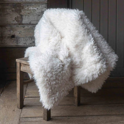 petit plaid fourrure blanc sur une chaise en bois 