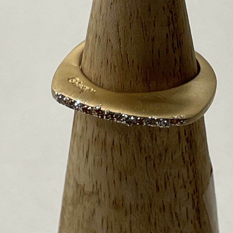 Bagues éclat prenium dorée sur un cône en bois devant un fond blanc