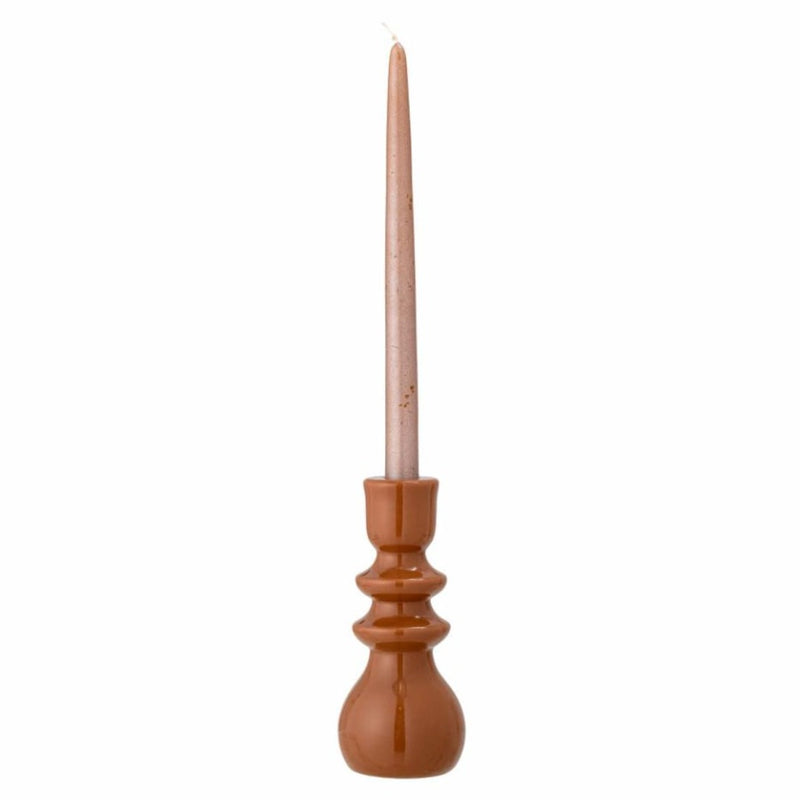 Bougeoir marron terracotta avec une bougie devant un fond blanc 