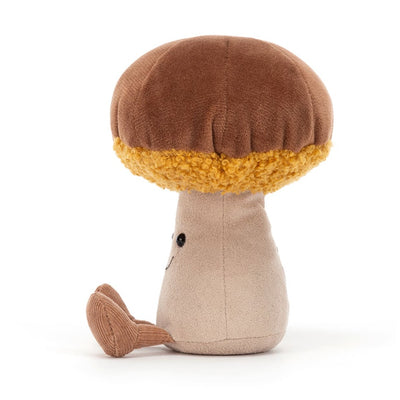 Peluche champignon de profil devant un fond blanc 
