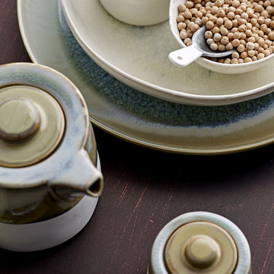 Gros plan sur une théière et des plats sur une table en bois 