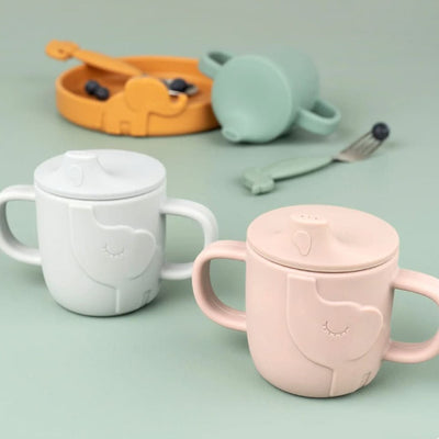 Verres éléphant rose bleu et gris devant fond vert 