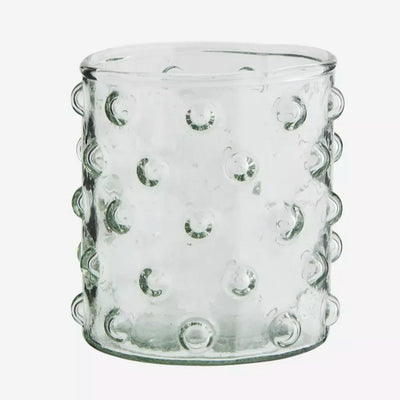 Verre transparent à points devant un fond blanc 